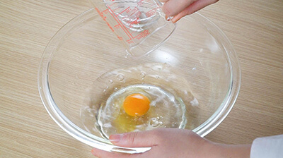 ボウルに卵を割り入れ、冷水を加えます